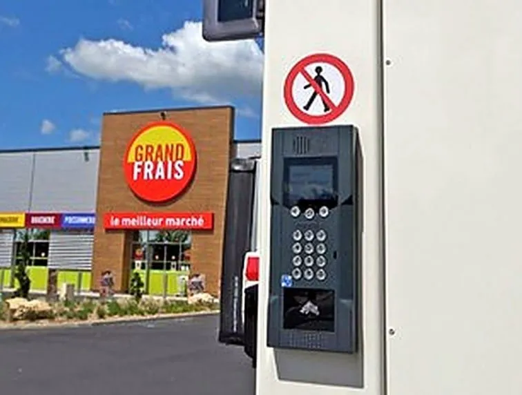 Digicode et platine d'interphone 4G installés à l'entrée d'un parking de magasin